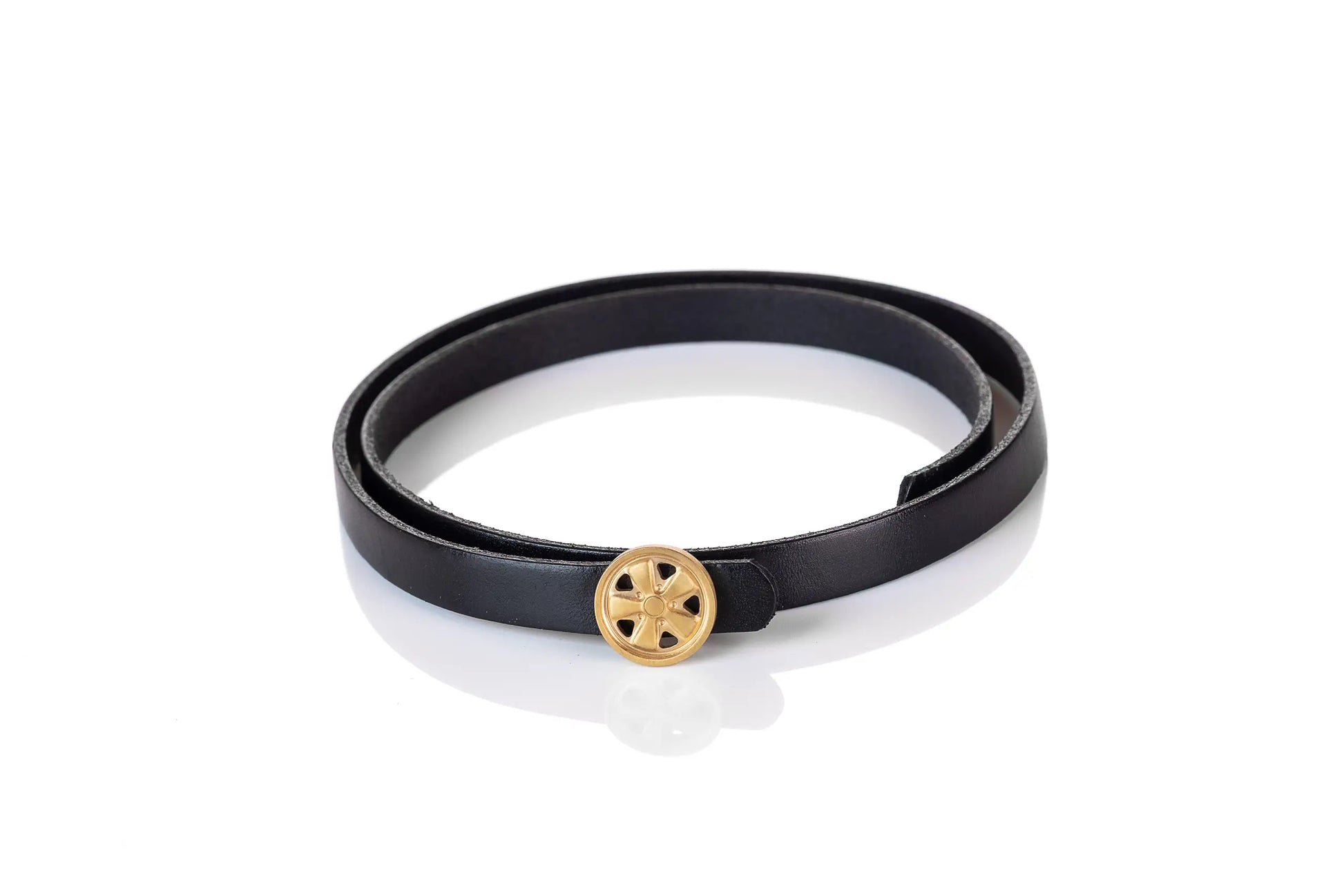 Ein schwarzes Lederarmband mit vergoldetem Knopf im Fuchsfelgendesign